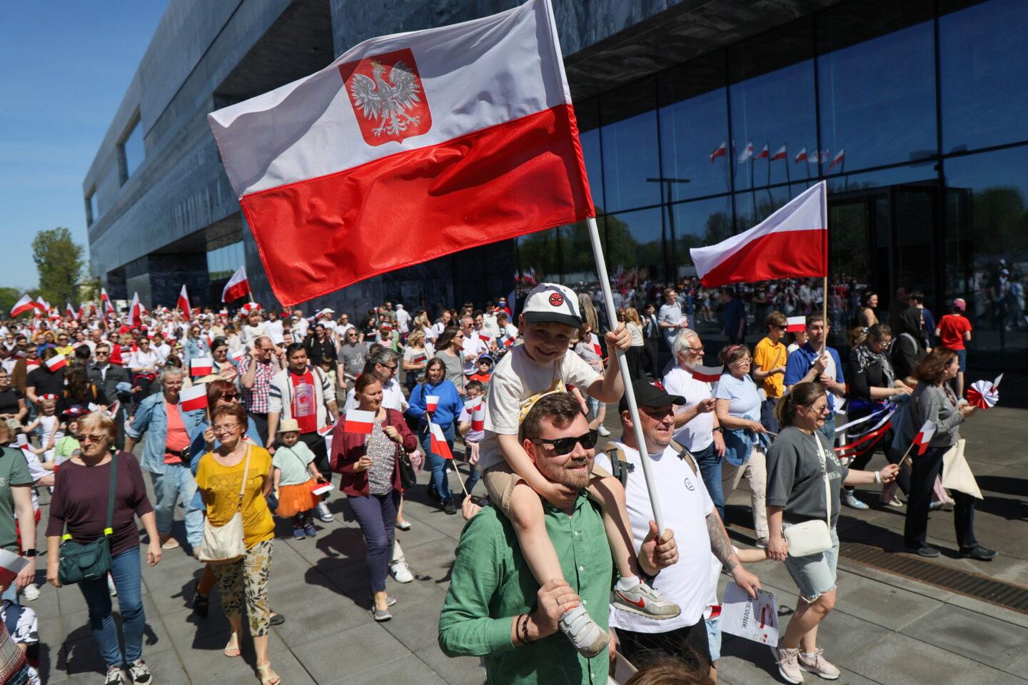 Tłum przechodniów z flagami Polski