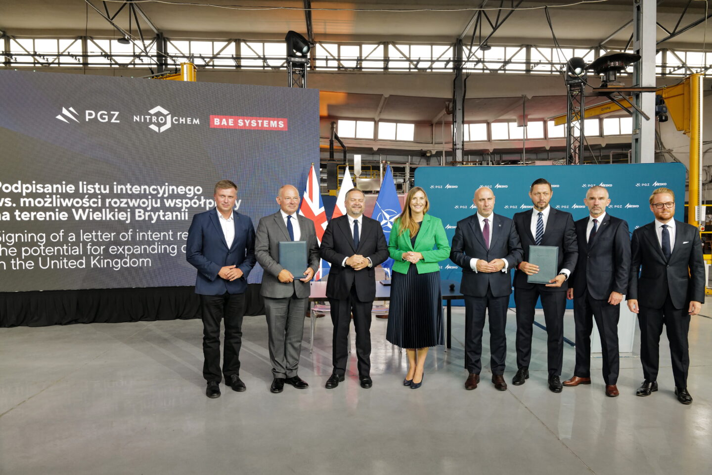 Od lewej: wiceprezes PGZ Arkadiusz Bąk, dyrektor ds. amunicji w BAE SYSTEMS Colin Weir, podsekretarz stanu w Ministerstwie Aktywów Państwowych Konrad Gołota, wiceminiser obrony narodowej Magdalena Sobkowiak-Czarnecka, prezes PGZ Adam Leszkiewicz, prezes NITRO-CHEM Karol Przybyszewski, członek zarządu NITRO-CHEM Andrzej Stanek i dyrektor zarządzający na Europę w BAE SYSTEMS David Williams