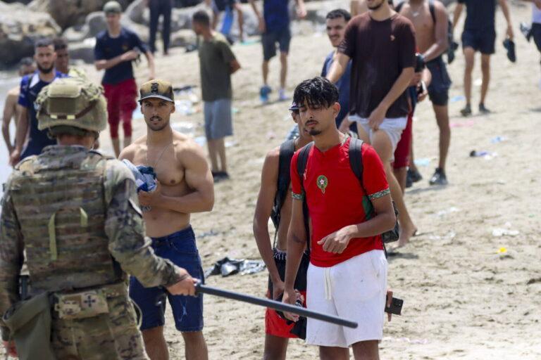 Hiszpański żołnierz w Ceucie i Marokańczycy, którzy dostali się do hiszpańskiej eksklawy