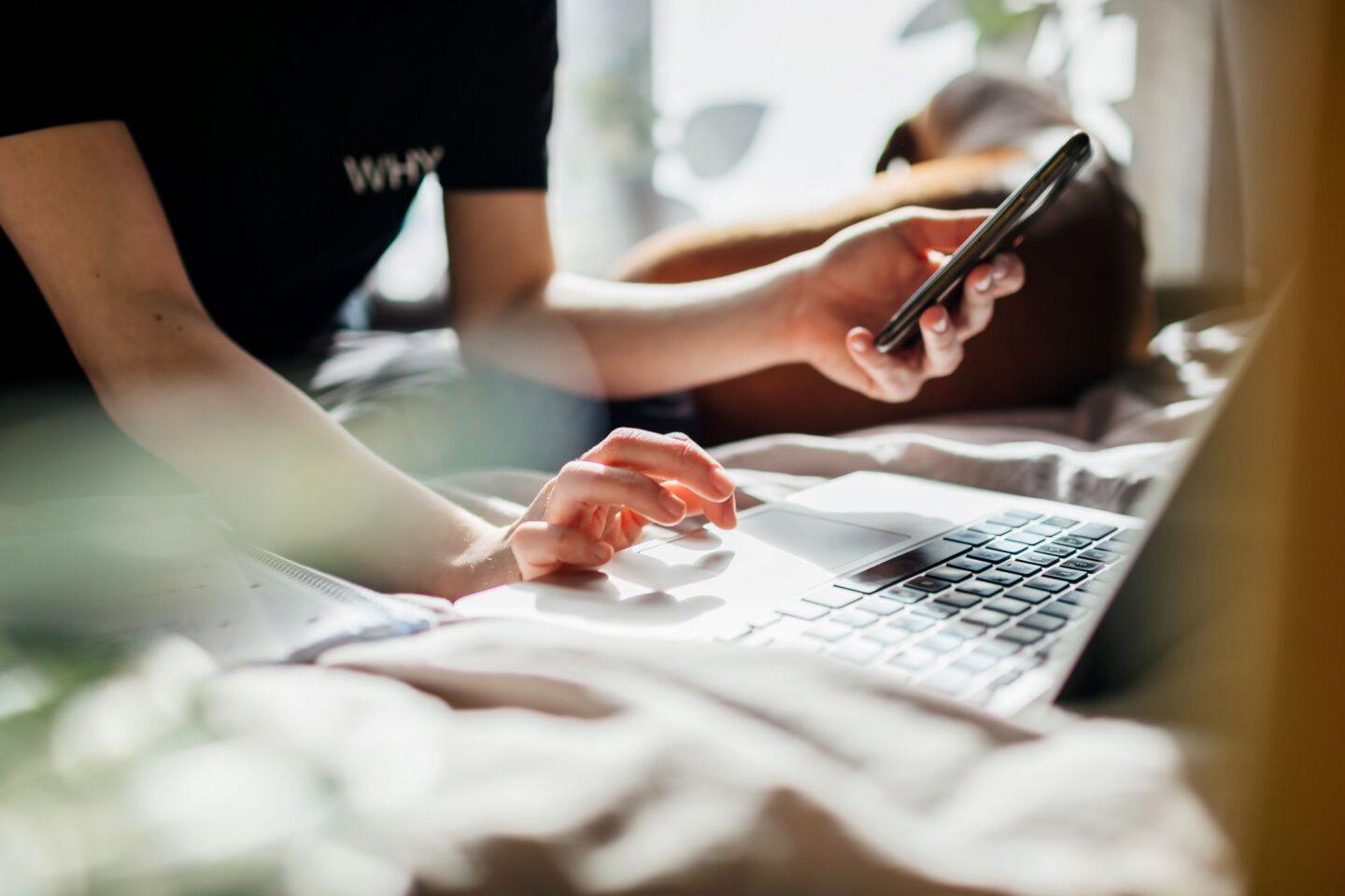 Osoba korzystająca z komputera i smartfona