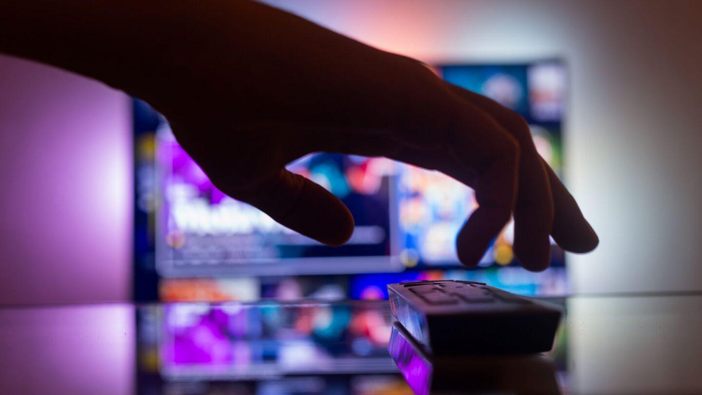 Ręka sięgająca po pilota do TV