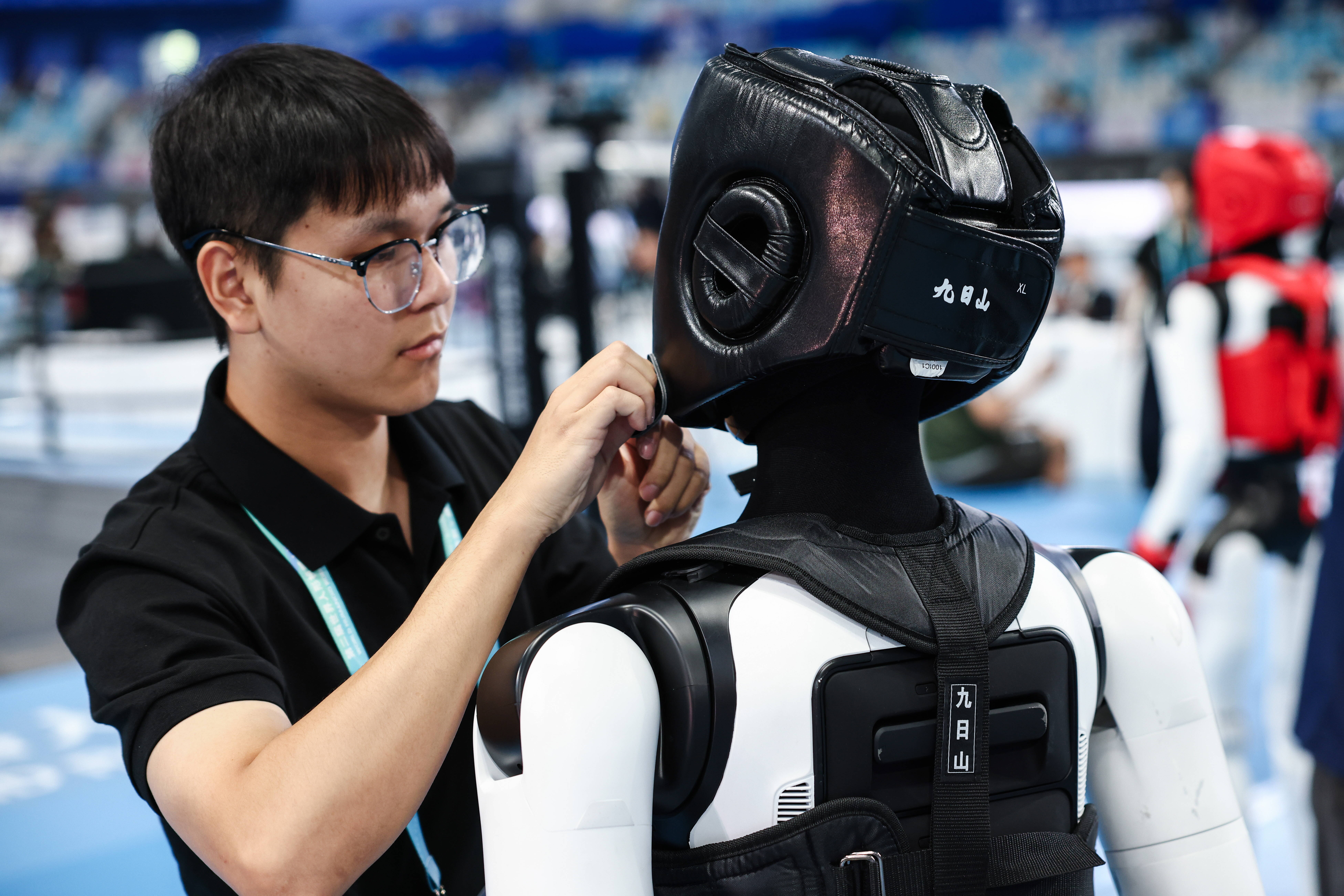 Mężczyzna w okularach manipuluje wokół humanoidalnego robota
