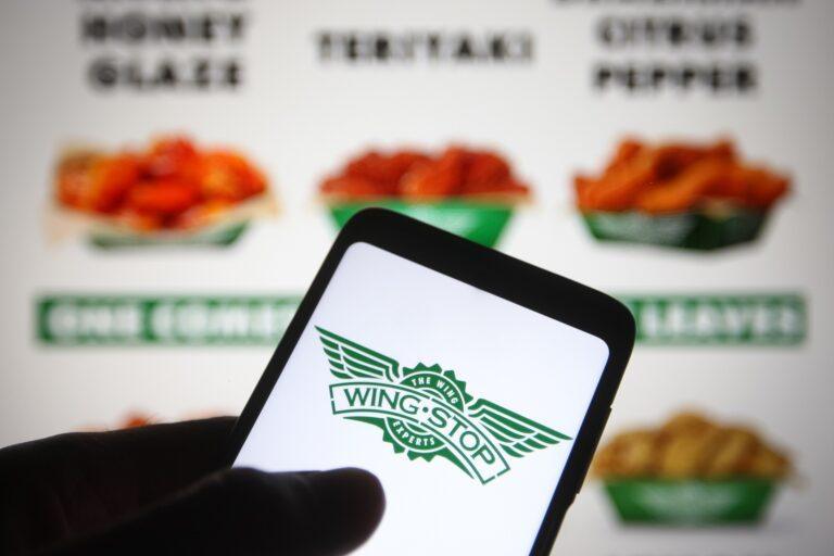 Logo Wingstop na ekranie smartfona na tle menu restauracji. Fot. Pavlo Gonchar/SOPA Images/LightRocket via Getty Images