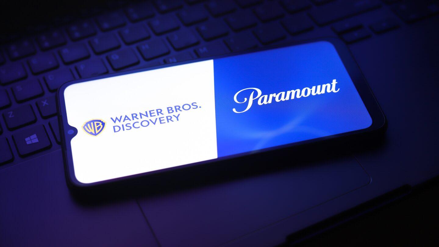 Logotypy Warner Bros. Discovery i Paramount na ekranie telefonu. Fot. Jaque Silva/NurPhoto via Getty Images