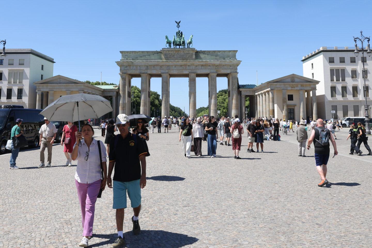 Przechodnie obok Bramy Brandenburskiej w Berlinie