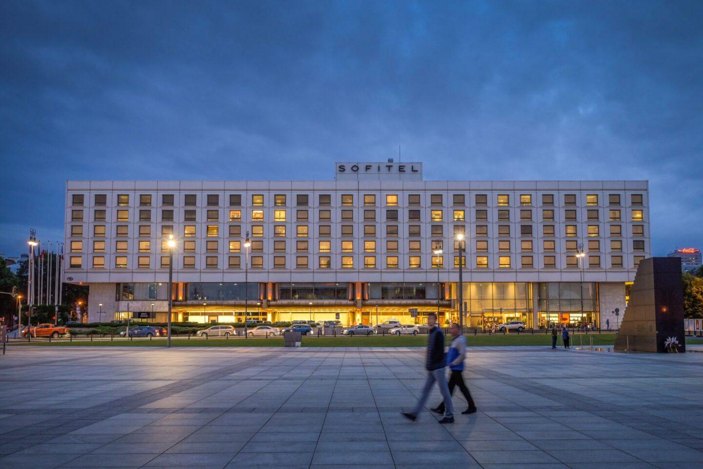 Osoby spacerujące po Placu Piłsudskiego na tle hotelu Sofitel Victoria