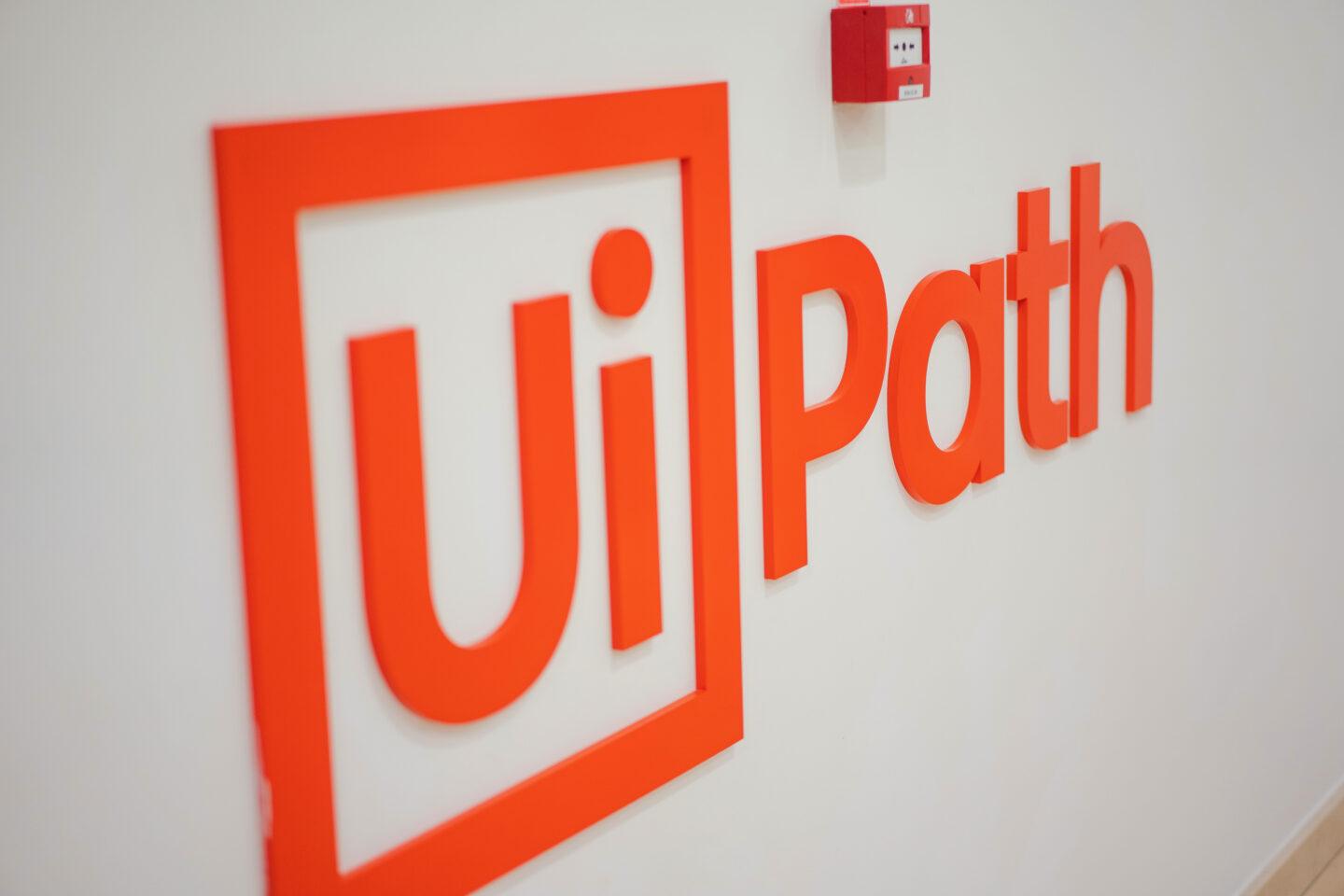 Pomarańczowe logo firmy UiPath na ścianie jej biura w Bukareszcie.