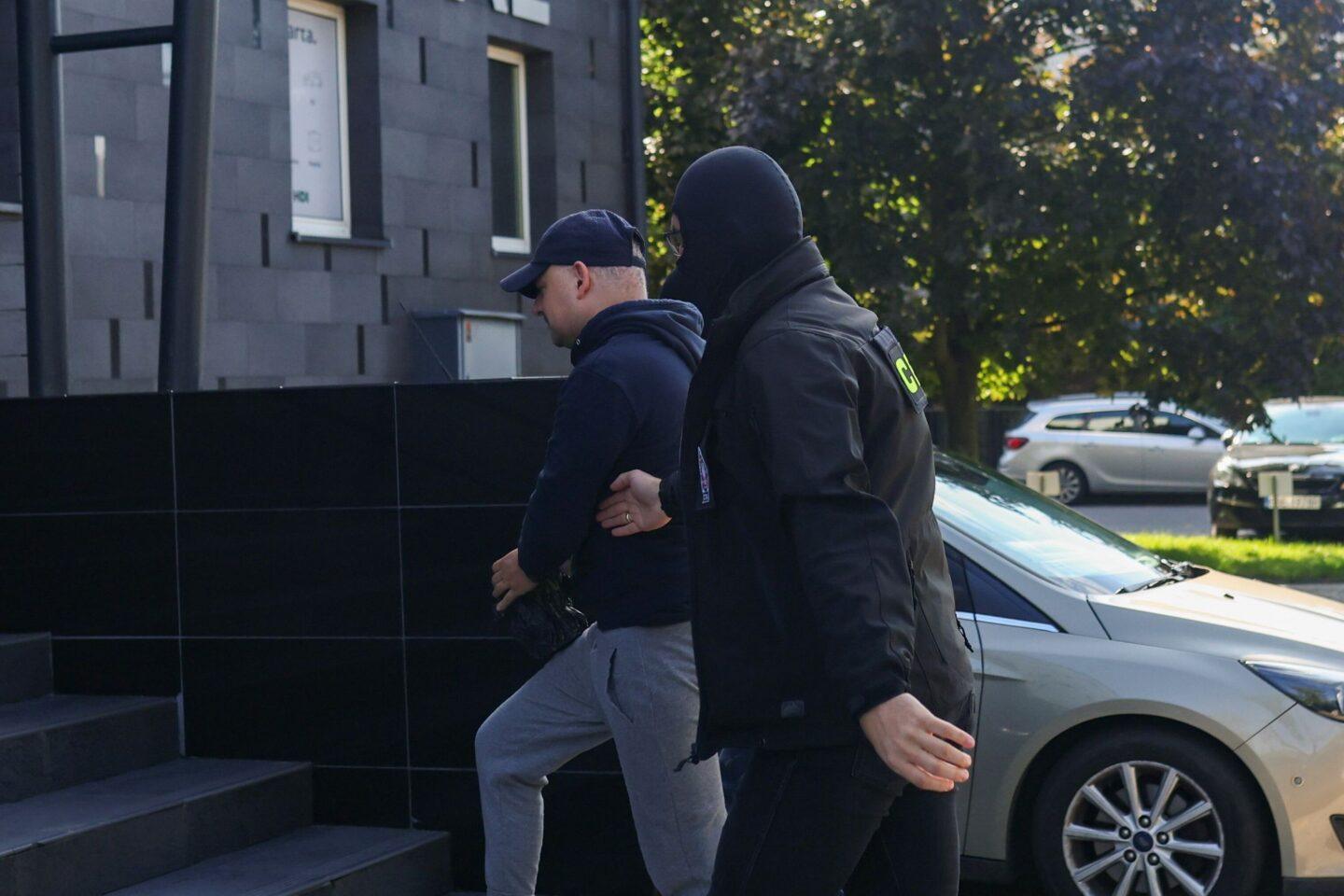 Poseł Wojciech Król (L) doprowadzony do prokuratury