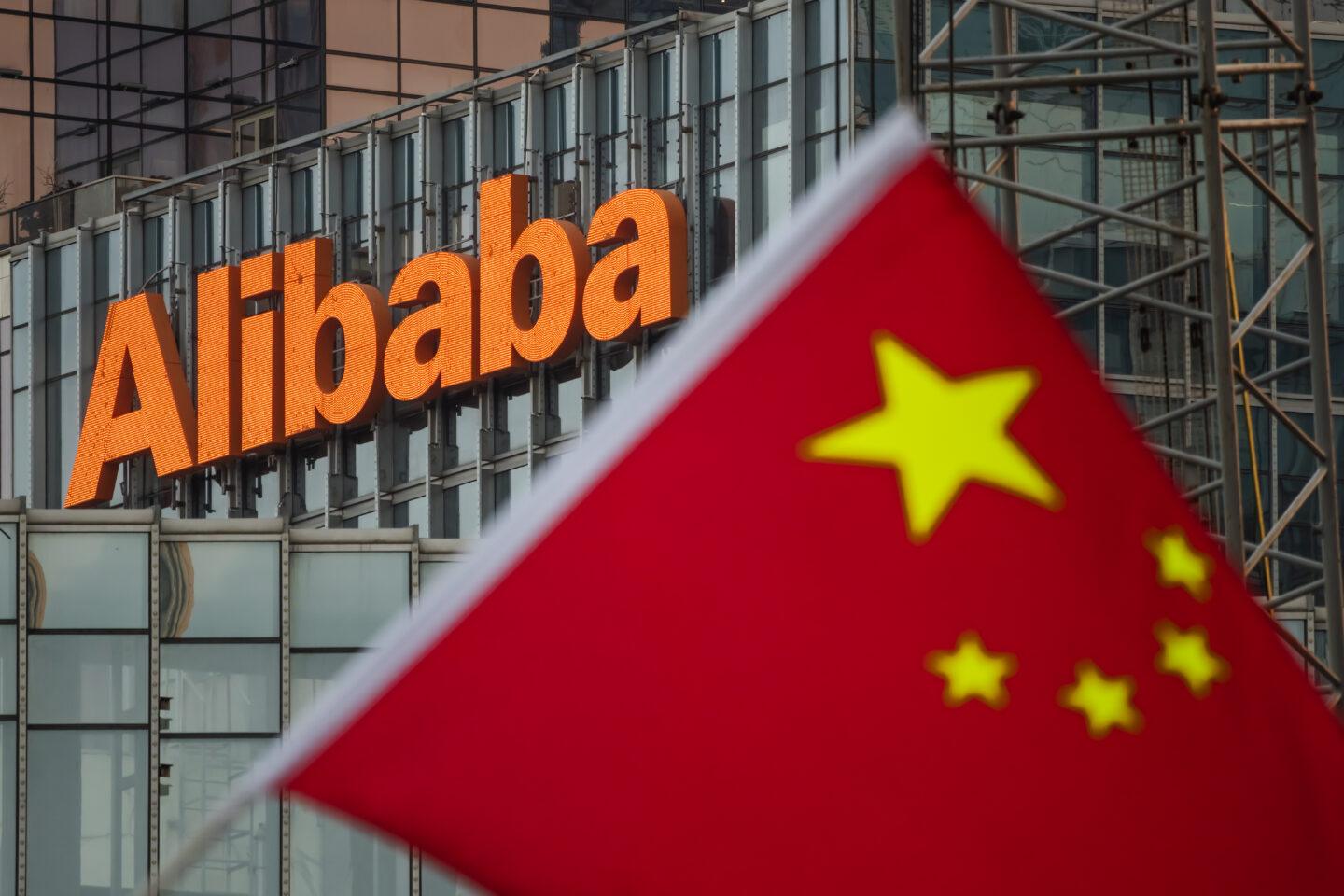 Logo firmy Alibaba, a przed nim flaga Chin